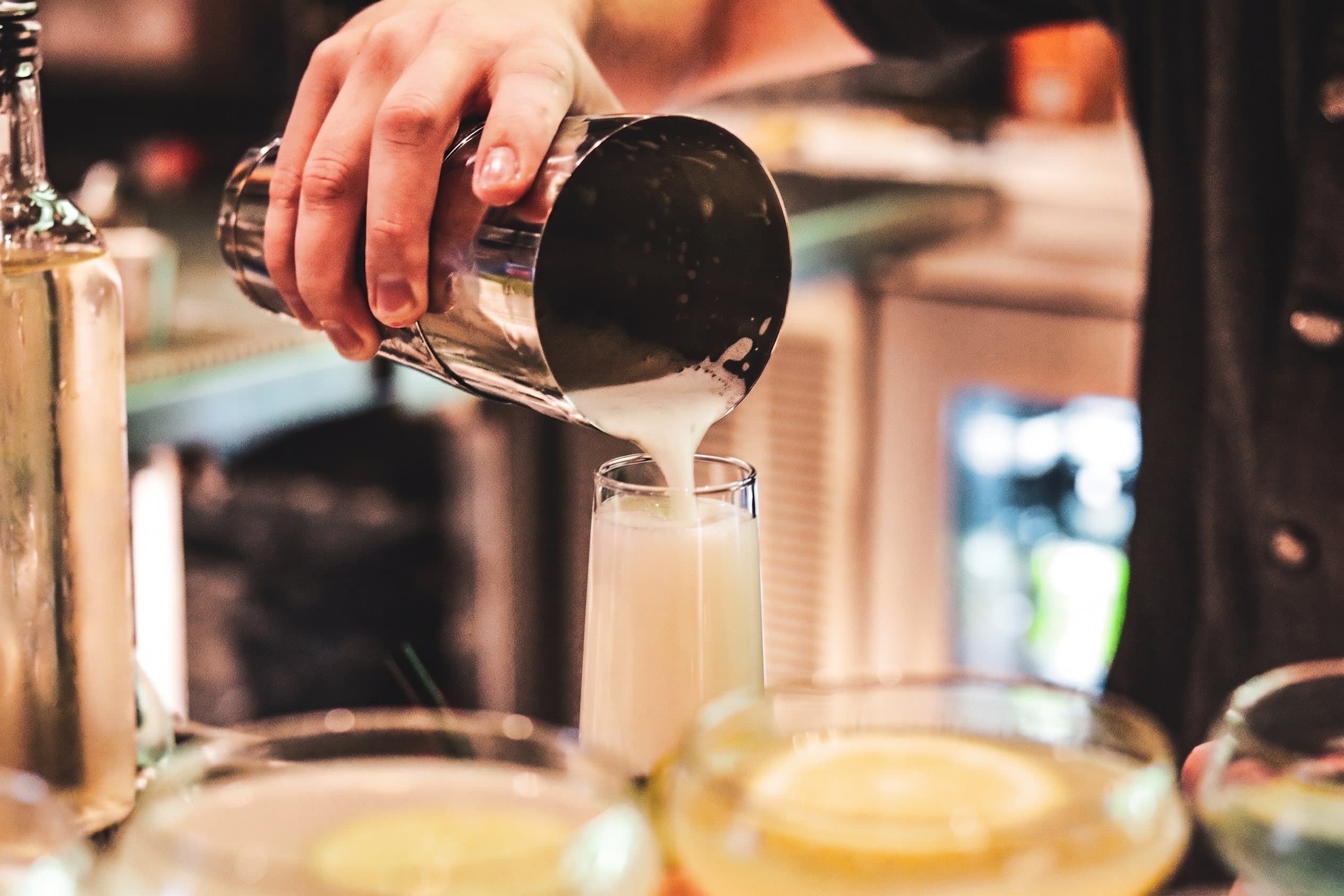 A bartender pouring a craft cocktail at the Zig Zag bar